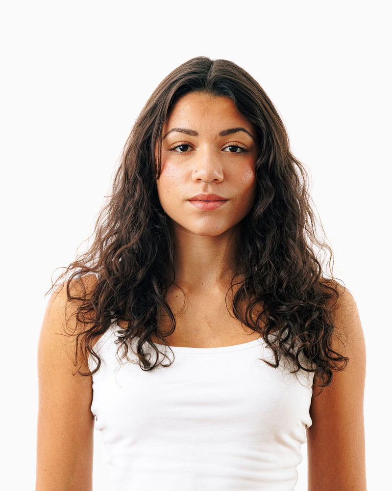 Before photo of long curly dark hair shown ahead of using Decibel thickening shampoo.