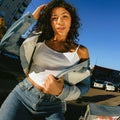 Outdoor lifestyle photo of woman with full, voluminous curly hair achieved with Decibel thickening hair care.