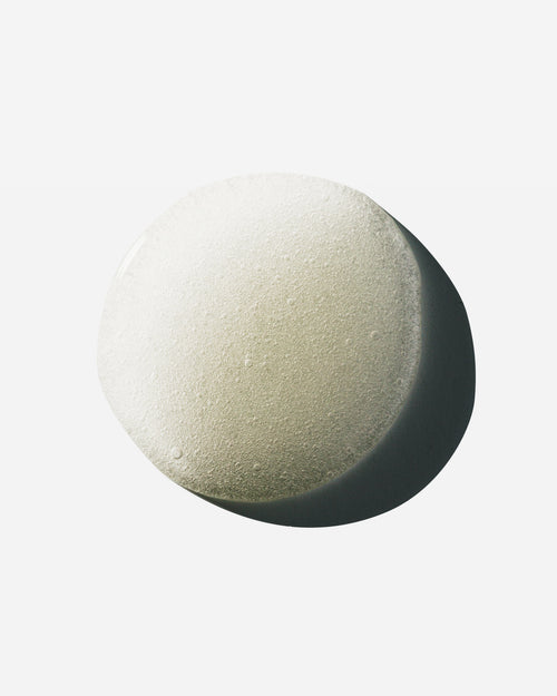 Droplet of Hypertrophy thickening hair treatment serum showing tiny bubbles on a white surface.