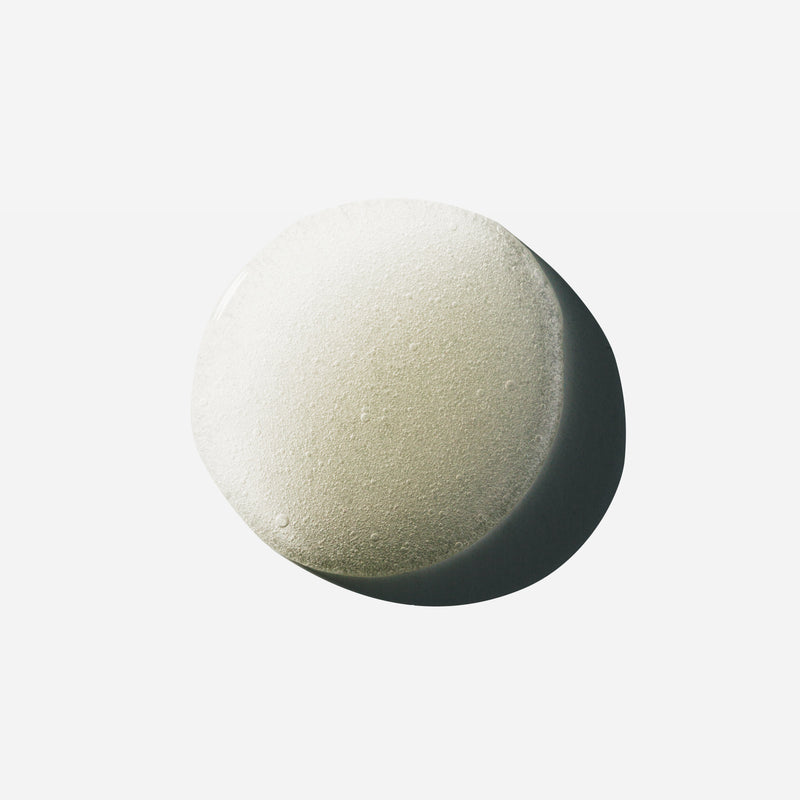Droplet of Hypertrophy thickening hair treatment serum showing tiny bubbles on a white surface.